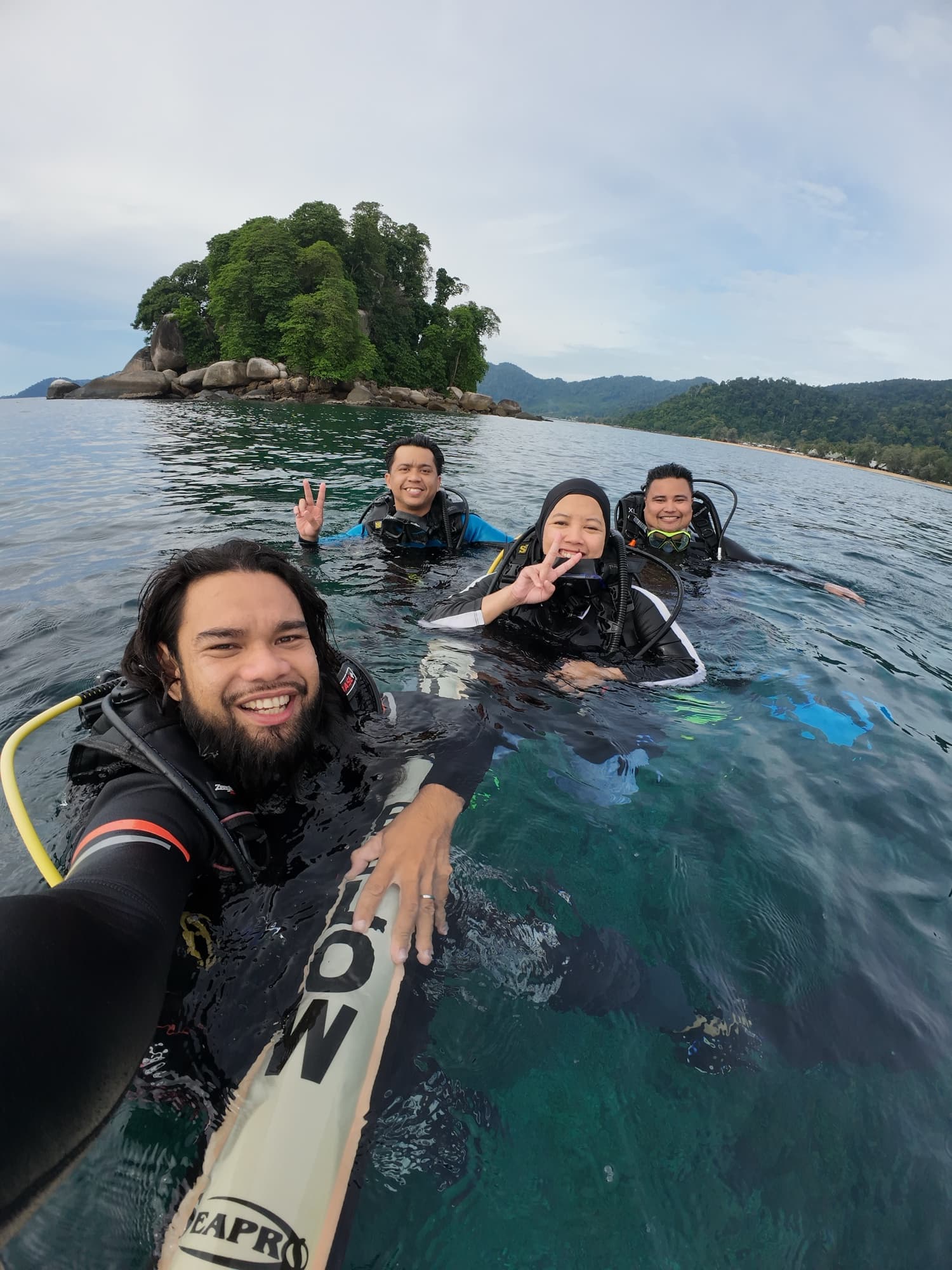 Divers together at the surface near an island
